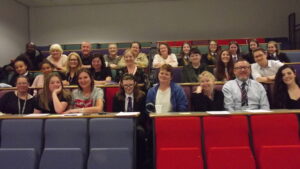Parents and carers and children in Knowsley sat in a university lecture theatre.