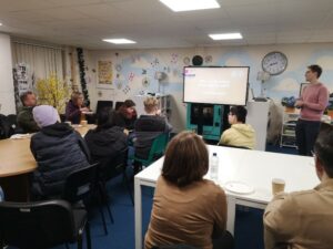 Parents and carers in Mansfield sat in a classroom facing a projector screen.